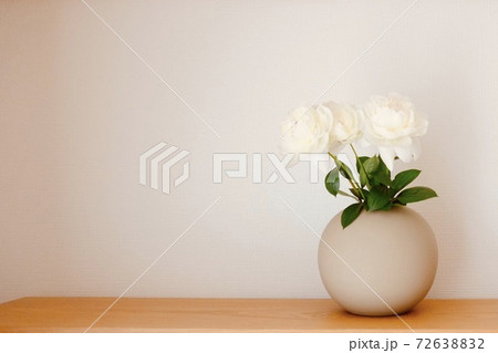 家の中で丸いピンクの花瓶に生けてある白い花の写真素材 [72638832