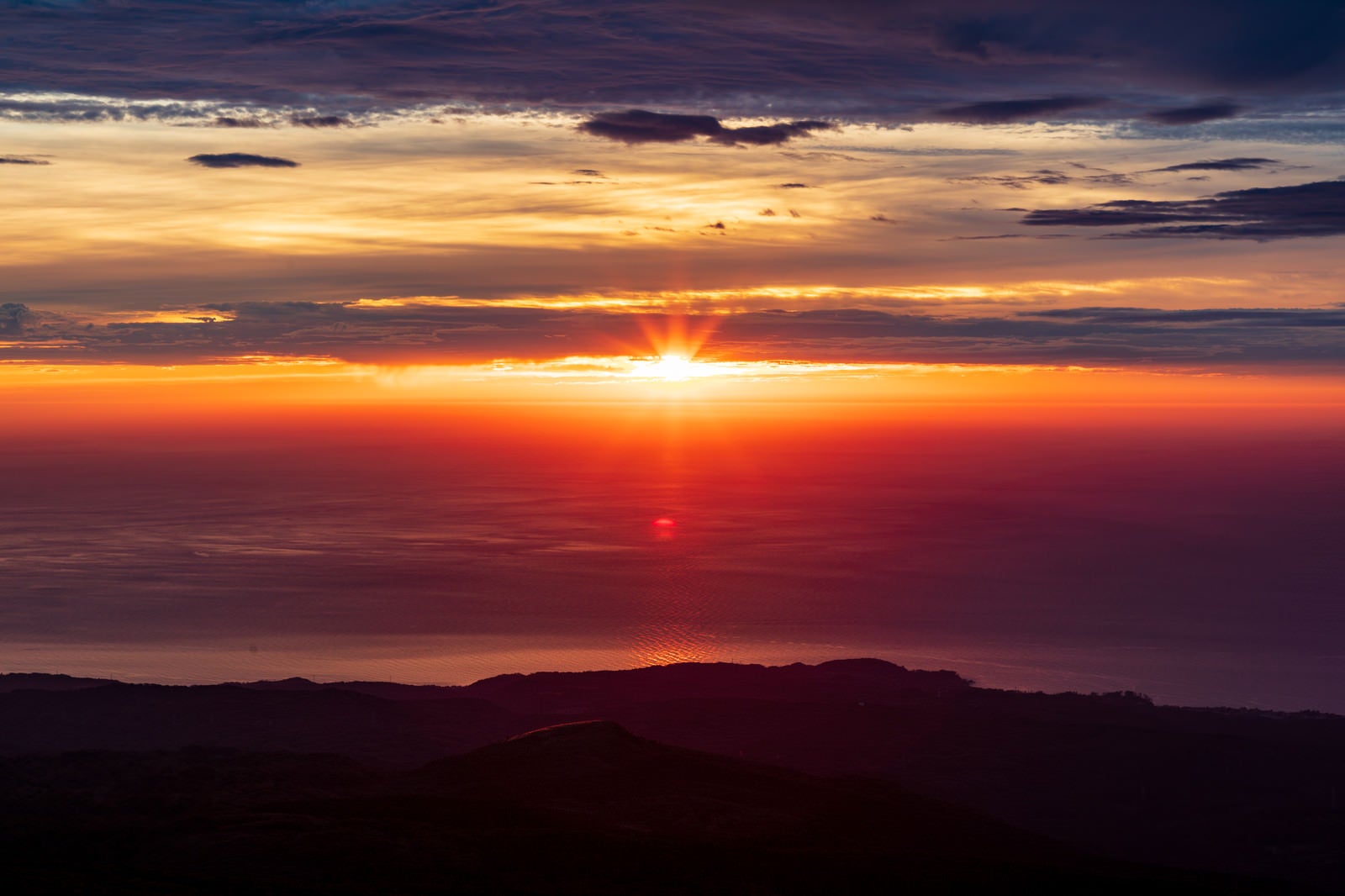 鳥海山から見るオレンジ色の夕日と山並みのシルエット - ぱくたそ