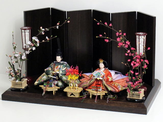 鳳凰の刺繍を全身にまとった豪華なおひなさまを紅白梅で引き立たせる